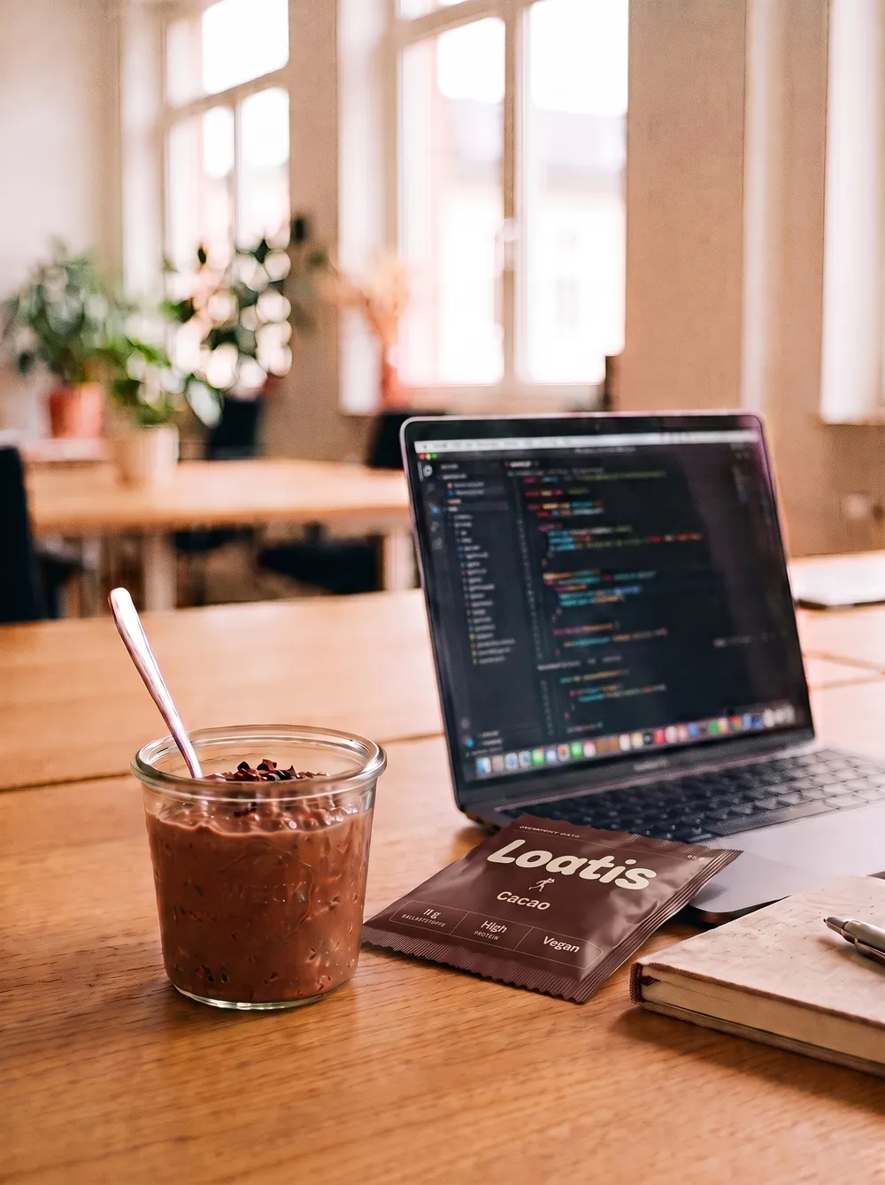 Schreibtisch mit einem Glas Overnight Oats neben einem Laptop
